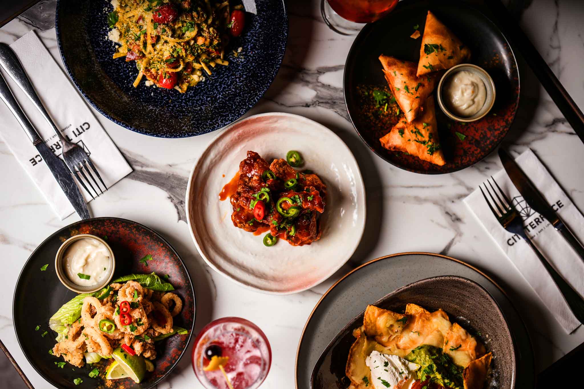 Sharing plates of pasta, samosas, wings and calamari at Citi Terrace